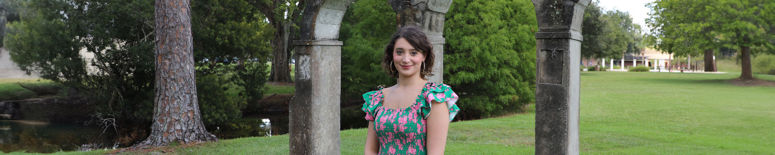 Natalie standing outside in front of arches