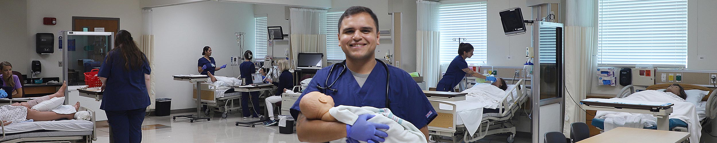 Nursing student holding manikin baby