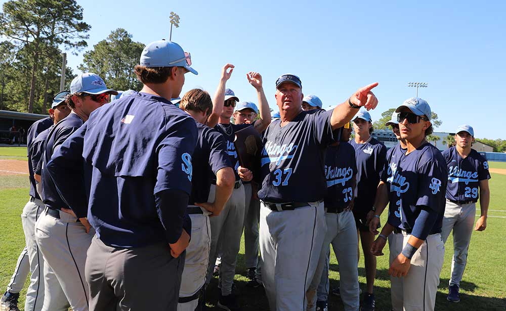 Head baseball coach Ross Jones surrounded by players